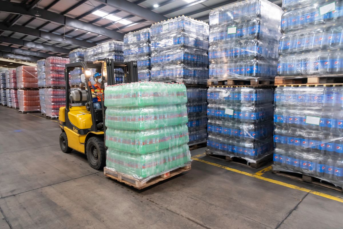Forklift moving palletised goods inside a distribution warehouse