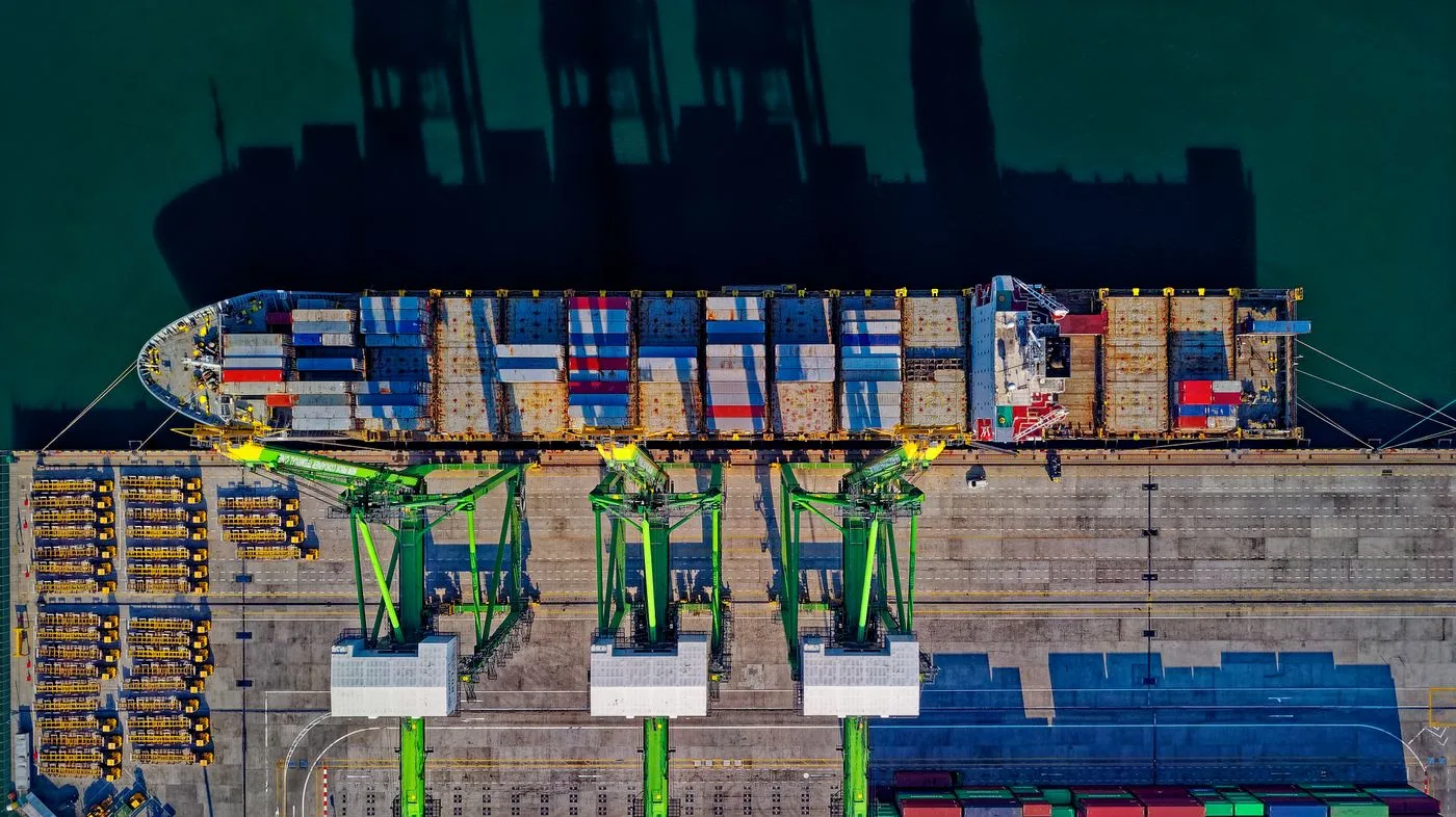 Aerial view of a busy container terminal with gantry cranes